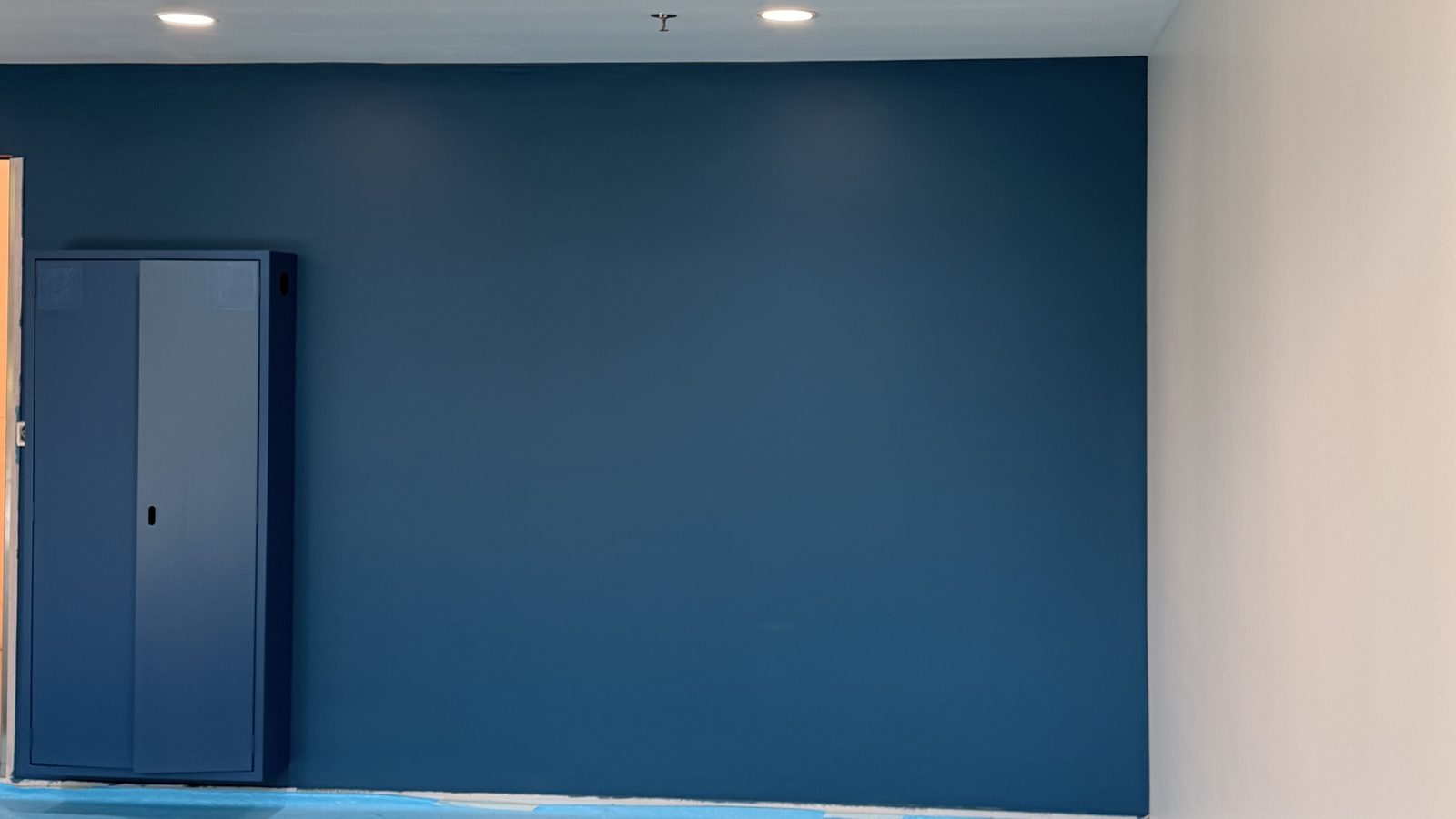 Mur bleu uniforme après mise en peinture
