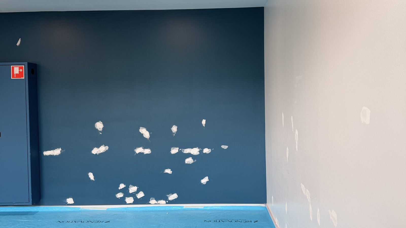 Mur bleu en cours de rebouchage, avant la mise en peinture